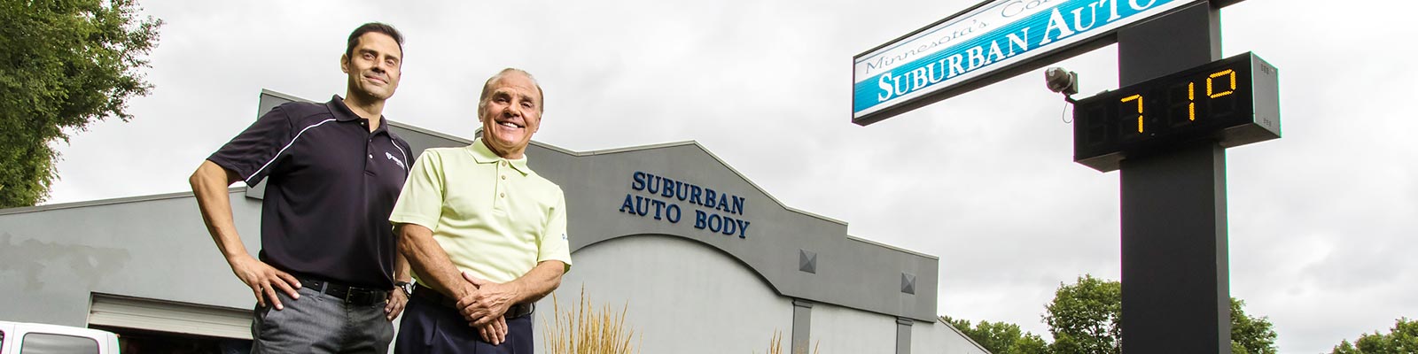 The owners of Suburban Auto Body standing in front of one of their locations in the Twin Cities
